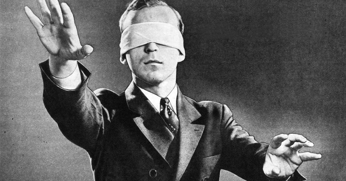 A blindfolded man in a suit evokes intrigue, attracting curiosity.