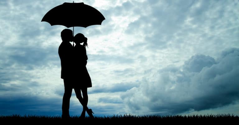 A silhouette of a couple embracing under a cloudy sky, revealing relationship truths.