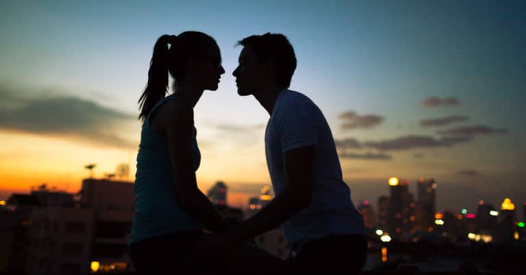 A man and woman, the love of your life, are silhouetted against the city skyline.