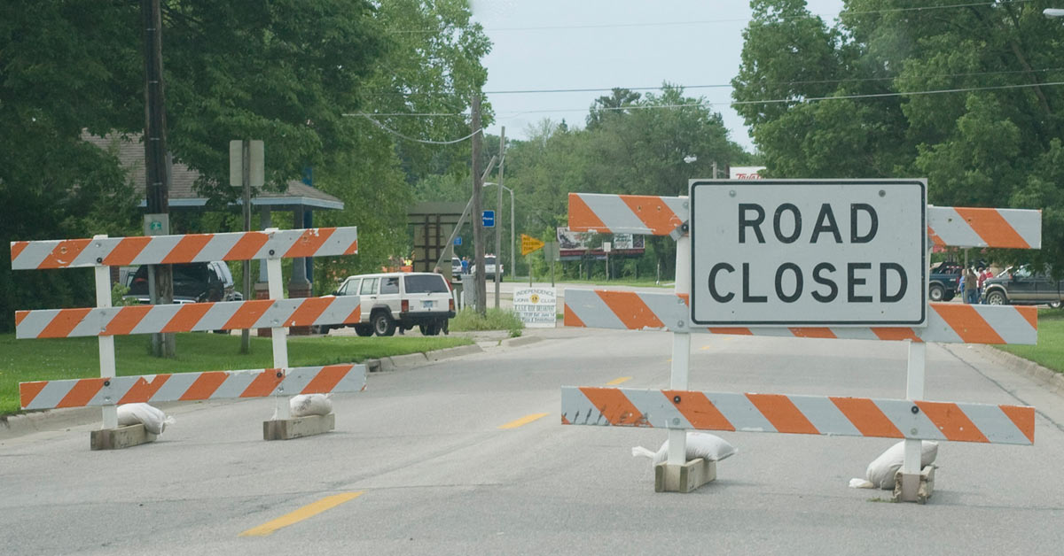 A mysterious road closed sign materializes in the midst of an open street, seemingly sent by unseen forces.