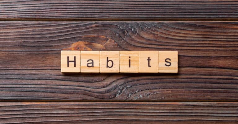 Successful people adopt secret habits, exemplified by the word spelled out in wooden blocks on a wooden background.