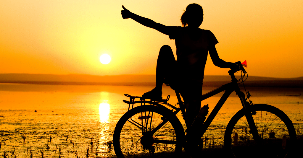 Silhouette of a person confidently biking.