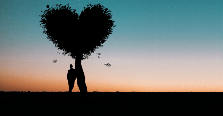 A silhouette of a man showing self-compassion by holding a heart-shaped tree.