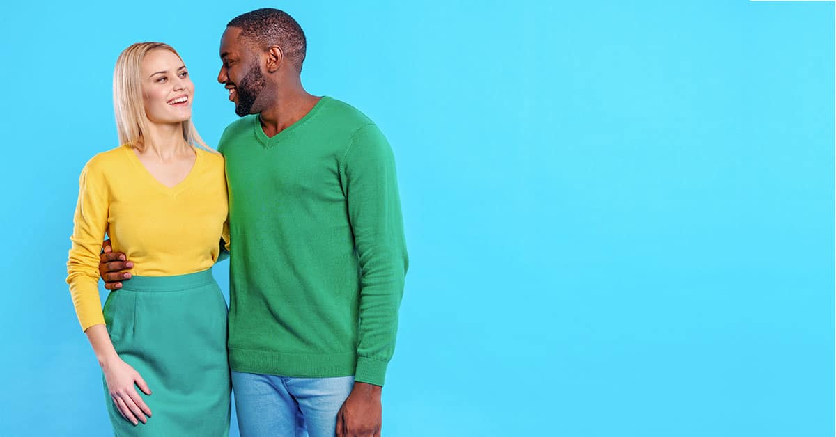 A man and woman embracing, radiating positivity against a blue background.