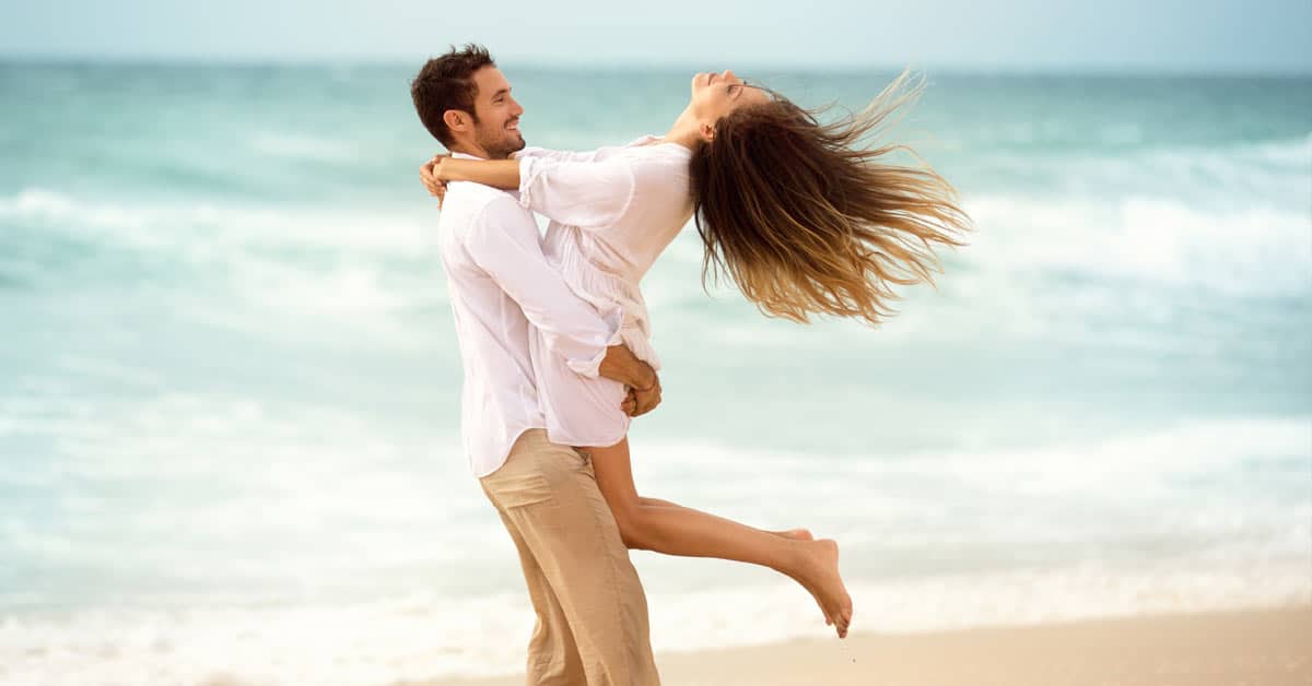 A successful couple hugging on the beach.