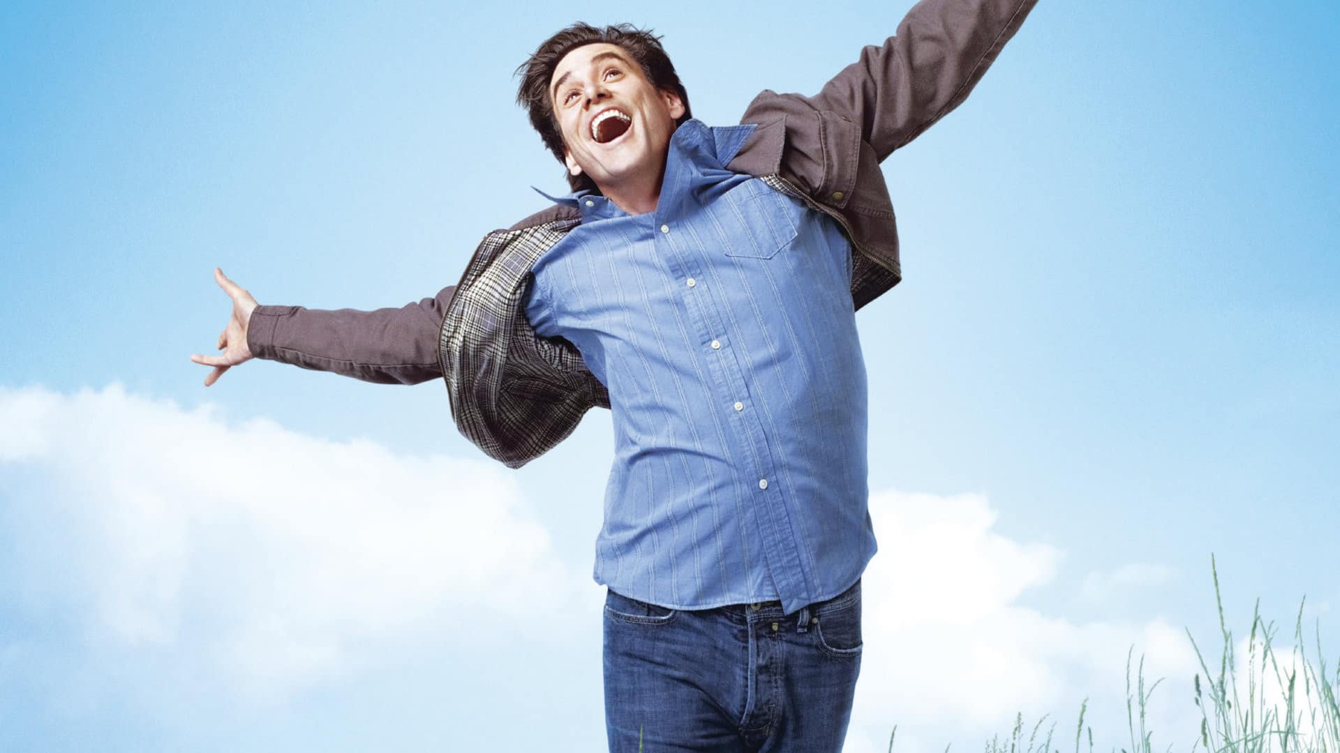 A man enthusiastically jumps in the air, arms outstretched, indicating his excitement.