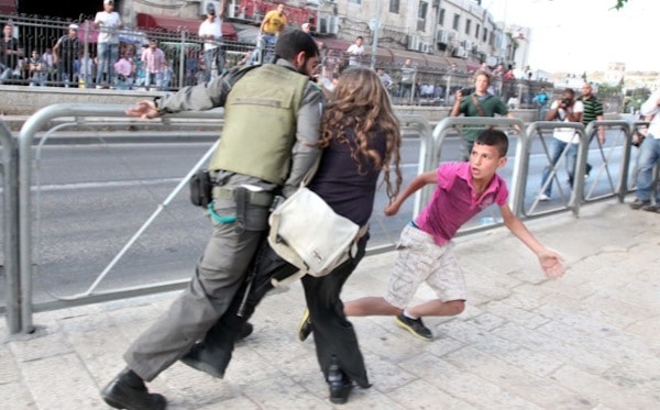 Israeli woman protects Palestinian boy from soldier...