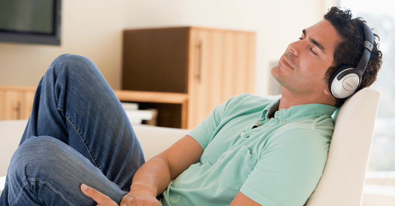Man relaxing listening to hypnosis audio on headphones